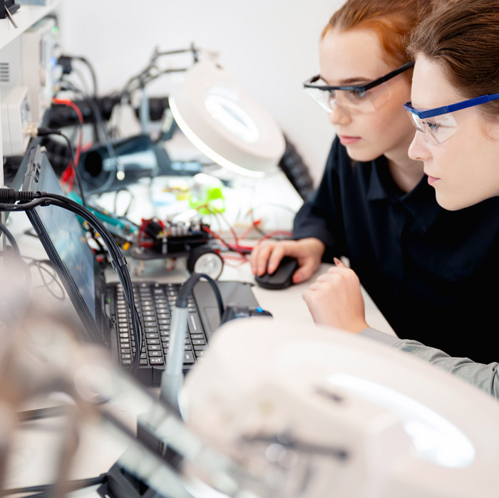 Zwei Frauen am Schreibtisch mit arbeiten an Elektronik.