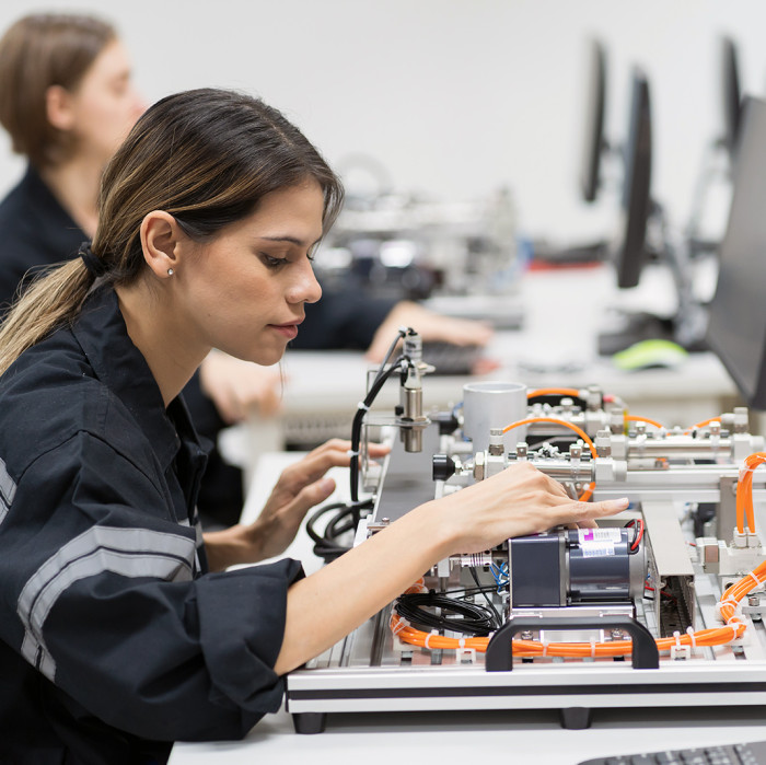 Woman sitting at a desk working with an electronic board.