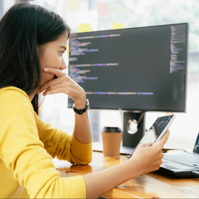 A woman works on her tablet and computer.